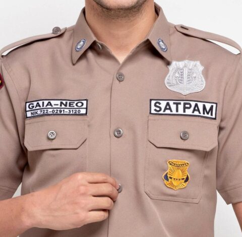 Seragam satpam coklat dengan atribut lengkap logo dan name tag tampilan depan